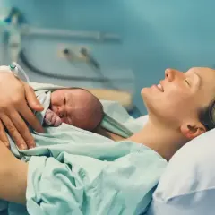 Szczęśliwa mama tuli noworodka po porodzie. Skurcze w 36 tygodniu ciąży zakończyły się narodzinami maleństwa.