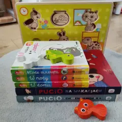 Zabawy z 16 miesięcznym dzieckiem: drewniane puzzle i książeczki "Pucio" zachęcają do nauki i wspólnego spędzania czasu.