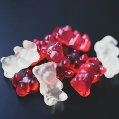 Kupa czerwonych i białych, przezroczystych żelków w kształcie misiów. Te zdrowe żelki wyglądają apetycznie.