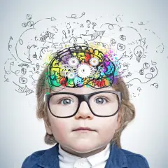 Dziecko w okularach z kolorowym mózgiem i zębatkami, symbolizujące rozwój układu nerwowego u płodu i proces myślenia.