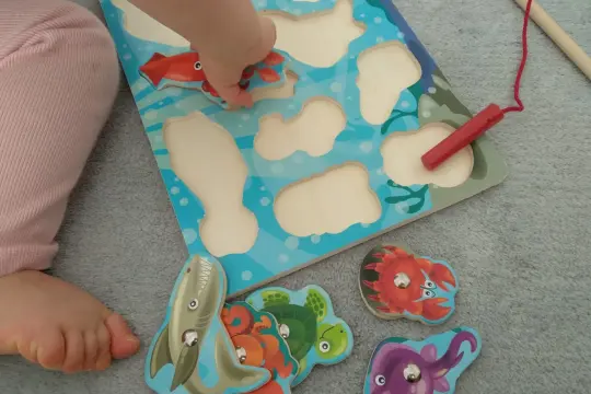 Małe rączki układają morskie puzzle. Wspaniałe zabawy dla 20 miesięcznego dziecka, rozwijające zdolności manualne i wyobraźnię.
