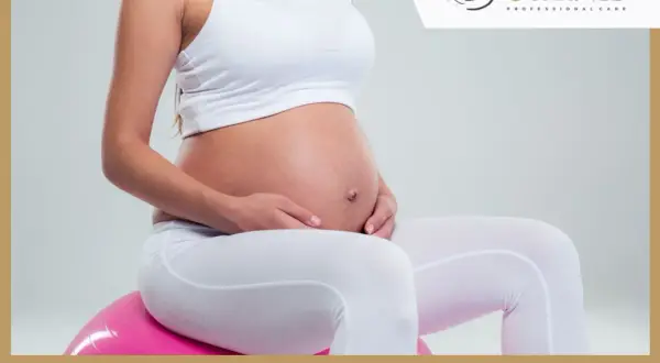 Brzuszek w 16 tygodniu ciąży, delikatnie otulony dłońmi. Czas na rozwój dziecka!
