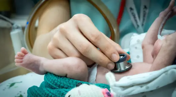 Delikatne badanie stetoskopem maleńkiego **wczesniaka kiedy** jest jeszcze w inkubatorze.