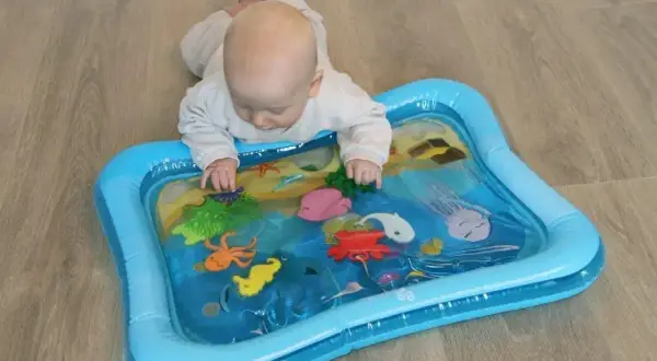 Niemowlę bawi się na macie wodnej z morskimi stworzonkami. Mata wodna dla niemowlaka od kiedy? Już od pierwszych miesięcy życia!