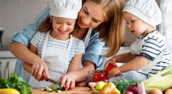 Mama z dziećmi w kuchni, przygotowują zdrowe jedzenie. Uczą się o składnikach, jak przy diecie eliminacyjnej.