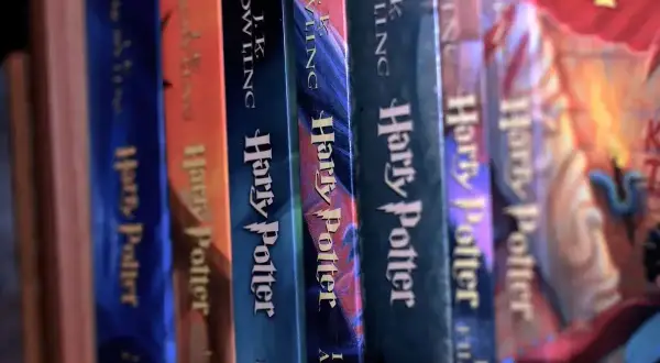 Rząd książek "Harry Potter". Zastanawiasz się, harry potter od jakiego wieku? Te magiczne historie wciągną każdego czytelnika!