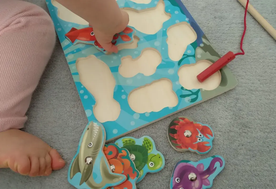 Małe rączki układają morskie puzzle. Wspaniałe zabawy dla 20 miesięcznego dziecka, rozwijające zdolności manualne i wyobraźnię.